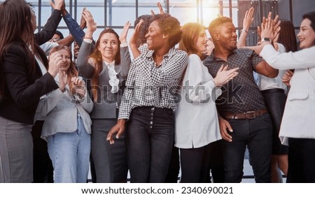 Excited multinational employees celebrating team victory giving high five gathered in office, Royalty-Free Stock Photo #2340690021