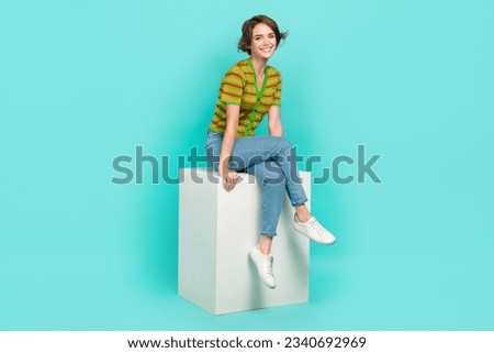 Full size portrait of funky satisfied girl sit podium good mood toothy smile isolated on aquamarine color background