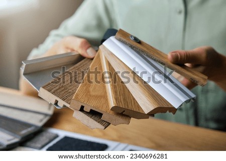 flooring shop salesperson showing skirting samples Royalty-Free Stock Photo #2340696281