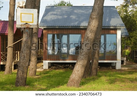 modern rustic house on pile with big panoramic windows and doors. new small Cottage in pine forest. summertime season. 