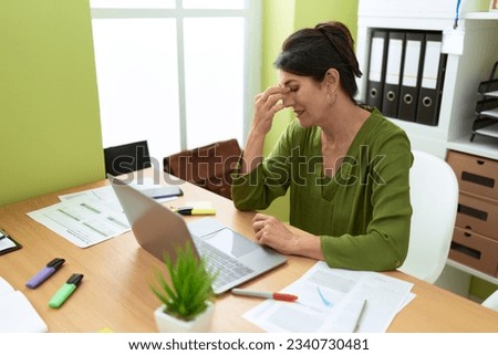 Middle age hispanic woman business worker stressed using laptop at office