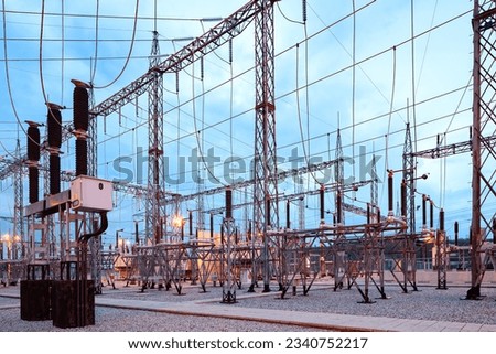 Illuminated electricity substation at dusk. Royalty-Free Stock Photo #2340752217