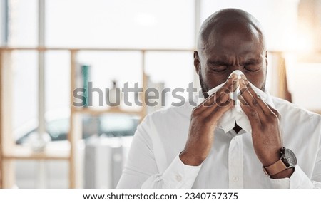Sick, tissue and businessman blowing his nose in the office with cold, flu or sinus allergies. Illness, medical and professional young African male person with hayfever while working in the workplace Royalty-Free Stock Photo #2340757375