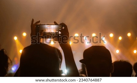 People holding smart phone and recording and photographing in concert , silhouette of hands with mobile , event background concept