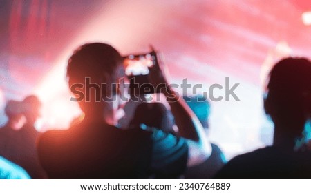 blured of People holding smart phone and recording and photographing in concert , silhouette of hands with mobile , event background concept