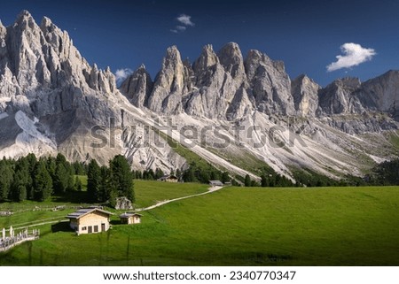 View of Geislergruppe or Gruppo delle Odle with chalet Dolomites, Italy , Europe. A beautiful view of the mountain peaks with beautifully lit green meadows
 Royalty-Free Stock Photo #2340770347