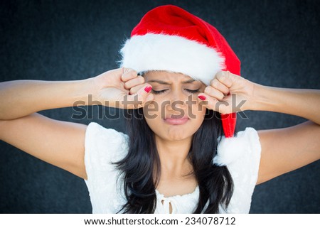 Closeup portrait, cute christmas woman in red santa claus hat, white dress, putting hands up to face about to cry, isolated gray black background. Negative emotion facial expressions