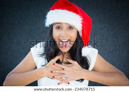 Closeup portrait of a cute Christmas woman with a red Santa Claus hat, white dress, exciting discounts, holiday shopping season, wide open mouth. Positive human emotion on isolated grey background.