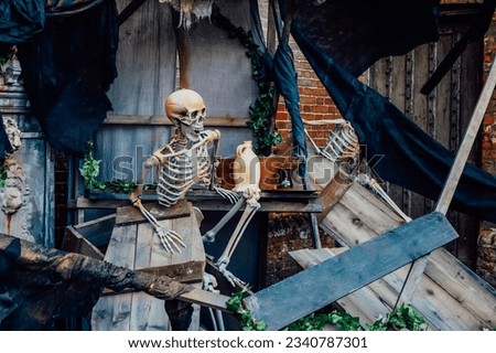 Outdoor Decor for Halloween. skeletons climbing out of the different wooden rubble. Halloween scenery. Terrible holiday photo zone on location for event. Traditions and decorations. Selective focus