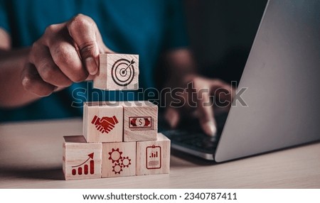Investment for ultimate goals, Targeting the business, business development concept. Hand arranging wood block stacking with business strategy and action plan.