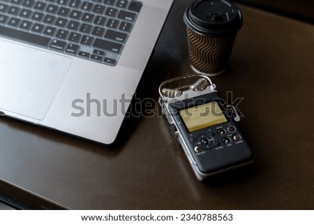 Focus on the voice recorder lying on the table.