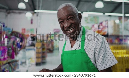 One Black Brazilian Senior Employee of Supermarket with Tablet, Inside Grocery Store. Portrait close-up face of an African American person at workplace