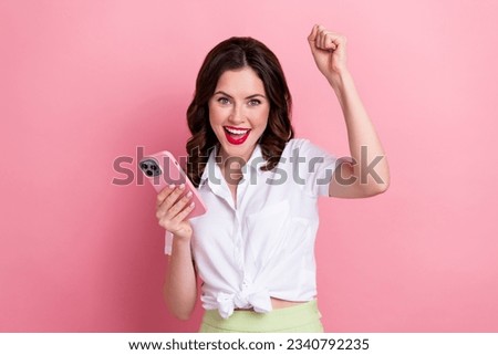 Photo of cheerful lucky young lady wear white shirt winning game apple samsung iphone modern device isolated pink color background