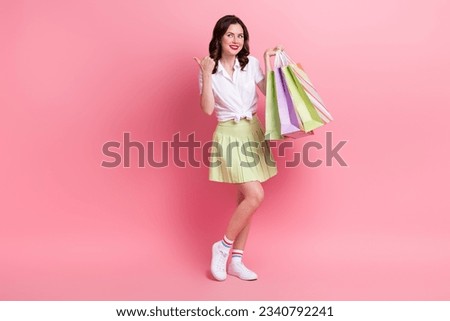 Full length photo of cute pretty girl dressed white top rising shoppers thumb empty space isolated pink color background