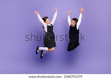 Photo of positive schoolkids jumping with raised hands up enjoying academic class courses isolated bright color background
