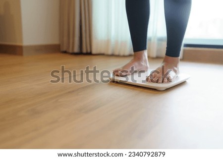 Lose weight. Fat diet and scale feet standing on electronic scales for weight control. Measurement instrument in kilogram for diet Royalty-Free Stock Photo #2340792879