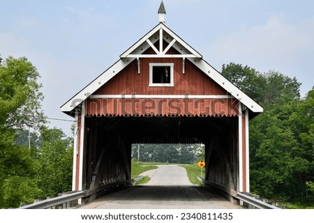 Vintage and historic wooden covered bridge down the rural dirt road