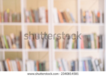Abstract blurred modern white bookshelves with books, manuals and textbooks on bookshelves in library or in book store, for backdrop. Concept for education