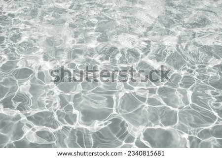 Abstract water background with ripples. Light caustics effect. Play of light and shadow, texture of twaves and splashes.