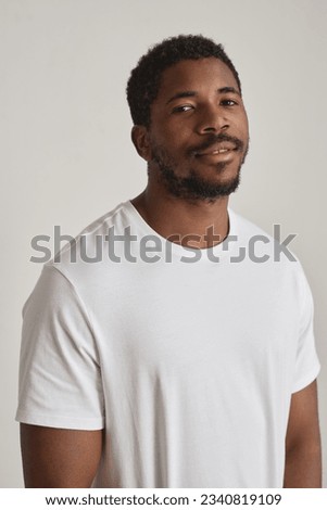Minimal portrait of handsome black man posing against white vertical