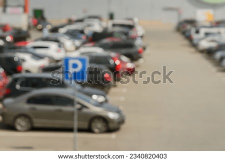 Blurred outdoor parking next to shopping mall, sunny summer day, season sales