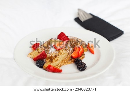 delicious french toast with berries served for breakfast in the hotel, in-room dining