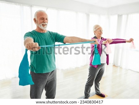 Senior couple exercise stretching and exercising with resistance band at home health care  Royalty-Free Stock Photo #2340830417