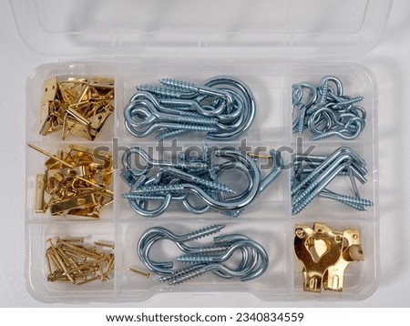 A set of different screws with a hook in a box on a white background. Close-up set.