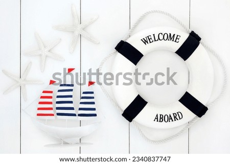 Abstract of seaside decorative sailing boat, lifebuoy and starfish over wooden white background.