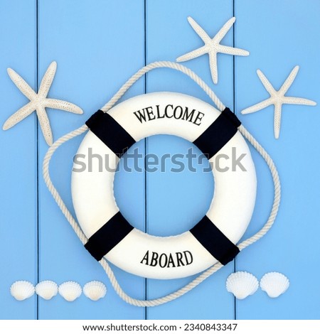 Decorative lifebuoy with starfish and cockle shells over wooden blue background.