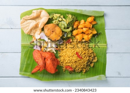 Overhead view of full length Indian biryani mixed rice on wooden dining table.