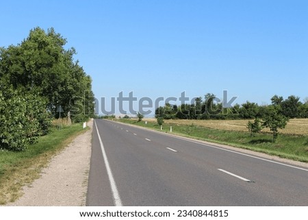 A road with trees and grass Royalty-Free Stock Photo #2340844815