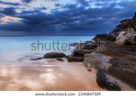 Tamarama Beach south side rocks on a dramatic, moody, windy overcast morning