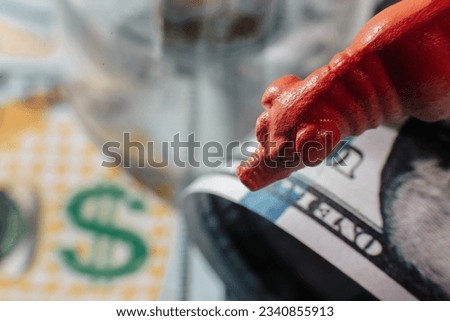 Miniature pig on American dollar bills and a dollar icon. Concept of economy, capitalism, savings.