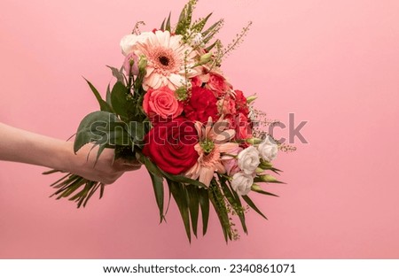 Real Human Hand Holding Beautiful Fresh Bouquet Of Flowers For Bride Or Occasion On Pink Background. Colorful Mixed Roses, Carnation Shabot, Green Leaves, Gerber. Horizontal Plane, Copy Space. Royalty-Free Stock Photo #2340861071