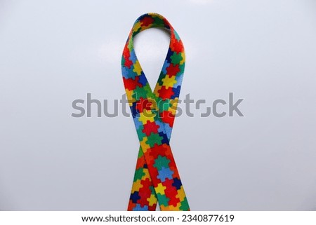 autism symbol - colored ribbon with drawings of colored puzzle pieces