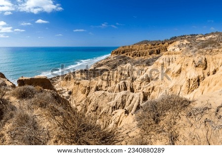 Torrey Pines State Natural Reserve beach side cliffs with sunshine and blue skies and water