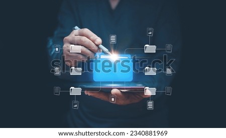 Online document management system concept, Businessman using smartphone and pen point to folder icon for manage information, document sharing, database tech, digital document paperless operation. Royalty-Free Stock Photo #2340881969