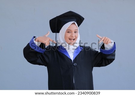 Asian girl student wearing toga cap and Graduation attire, Graduation concept with grey background.