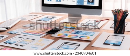 Digital and paper wireframe designs for web or mobile app UI UX display on laptop computer screen. Panoramic shot of developer workspace for brainstorming and design application framework. Scrutinize Royalty-Free Stock Photo #2340904601
