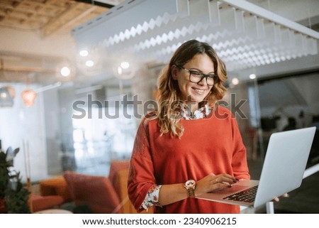 Young woman using a laptop while working in a startup company office Royalty-Free Stock Photo #2340906215