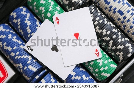 High-stakes Texas Hold'em poker chips and cards symbolize risk, chance, and adrenaline in gambling at the casino. Bet for fortunes Royalty-Free Stock Photo #2340915087