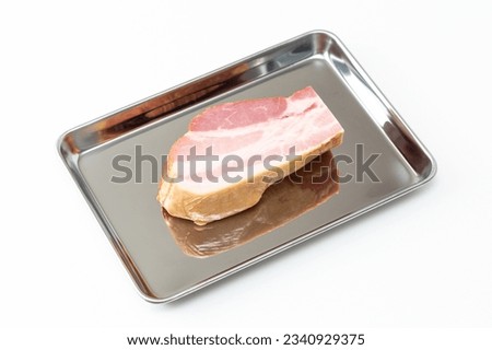 Block bacon on the cooking tray.