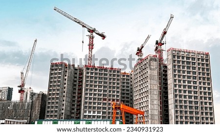 Tower crane in action to build multi-storey residential building. Royalty-Free Stock Photo #2340931923