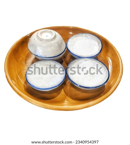 White dessert cups served on a brown porcelain plate.  Thai style, white background