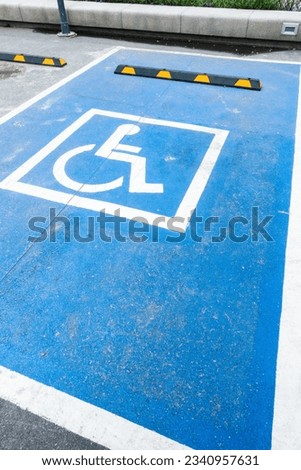International handicapped symbol painted in bright blue on a shopping center parking space,Disabled parking sign, road traffic signs.