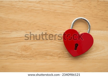 Love red heart shape padlock on wooden background with copy space. Find love, romantic, dating in online internet website, app dating community platform and Valentine day love symbol concept.