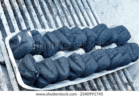 Charcoal stacked in an egg cartilage on a barbecue 