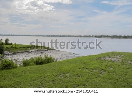 scenic river banks of ichamati river with abandunt greenery and tranquil water with the cloudy sky