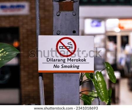 no smoking sign on a foundation pillar at a city station